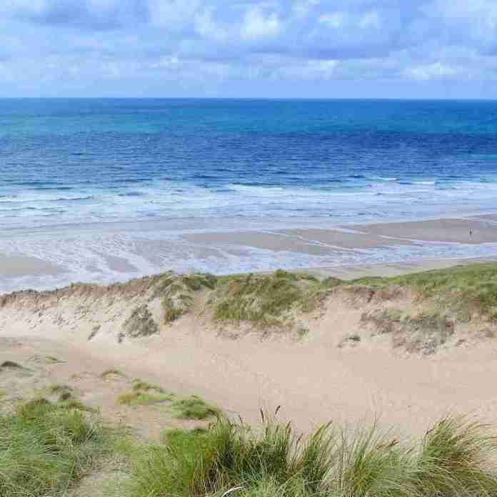 Inspirational Cornish sand dunes, blue sea, white clouds and horizon to inspire creative writing students in Cornwall.
