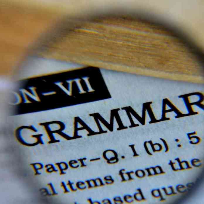 Magnifying glass, magnifying the word 'grammar', a crucial element of any creative writing project.